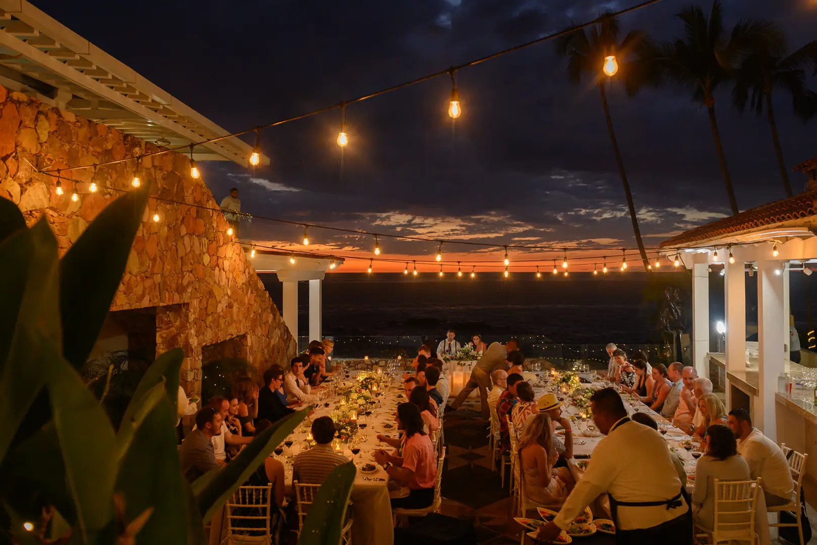 Night dinner under string lights on the middle terrace